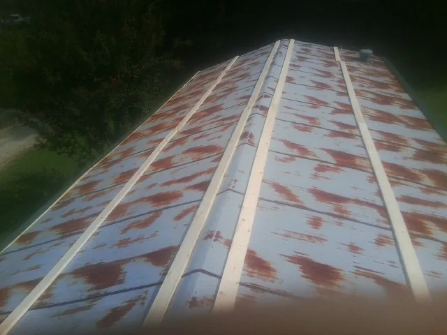 Rusted metal roof panels with new wood purlins before replacement — Storm Damage Roof Repair in Arbon by Roofing Brothers
