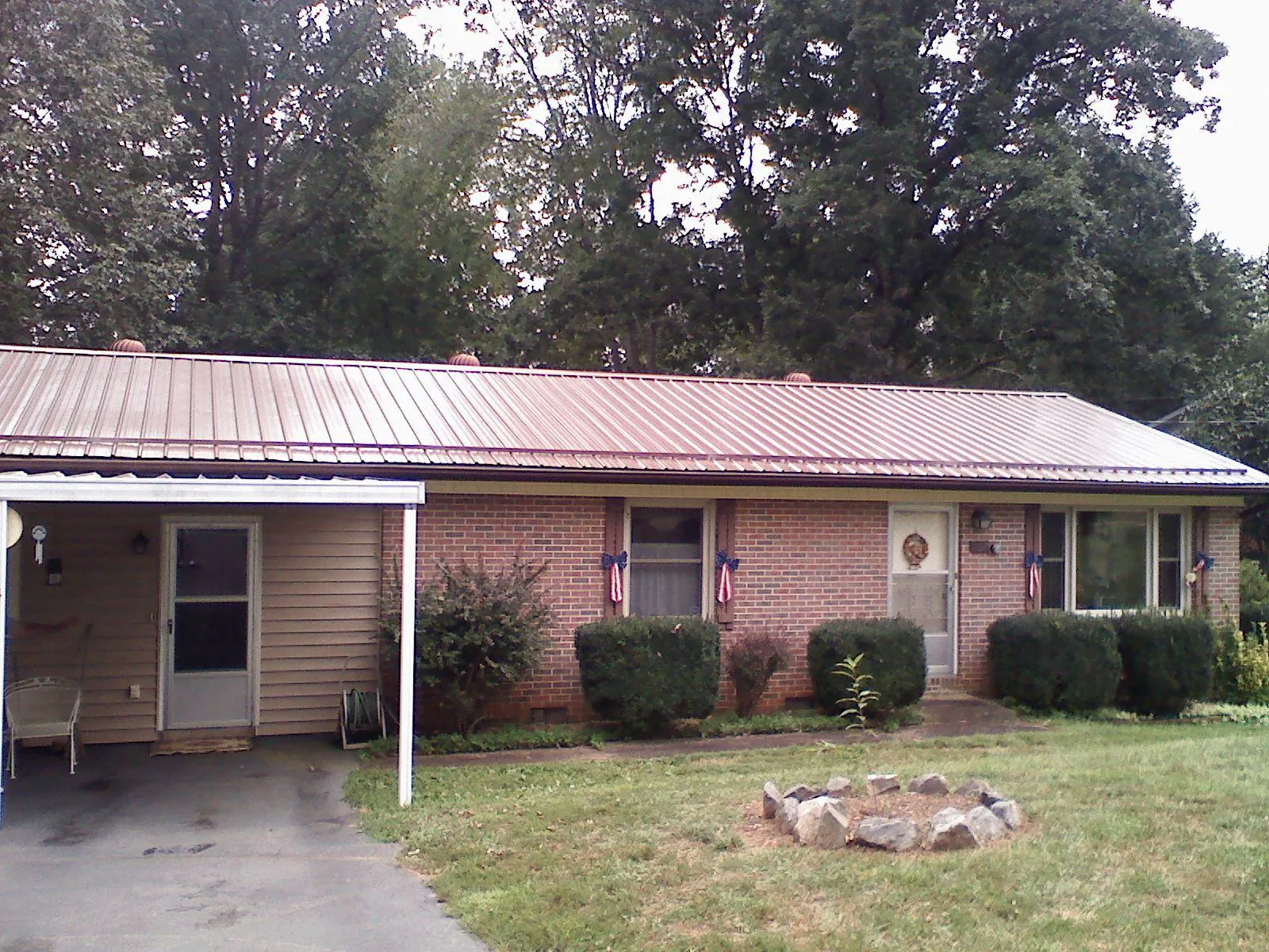 Bronze metal roof and carport on a brick ranch home — Roof Repair work by our crew in Arbon