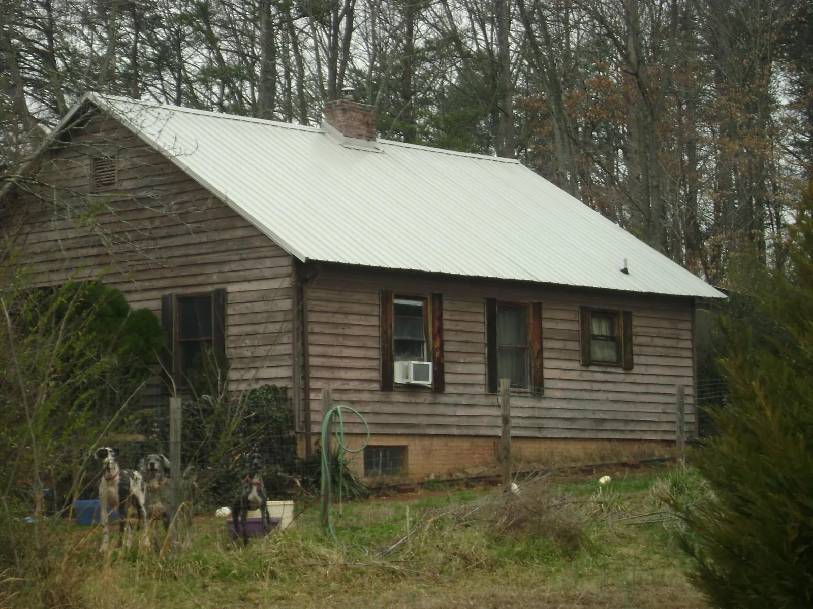 White metal roof on an old wood sided farmhouse, from a Metal Roof Installation job in Arbon